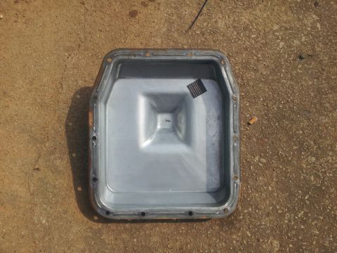 1988 Ford Bronco - Transmission oil pan shown from above, resting on a concrete surface.