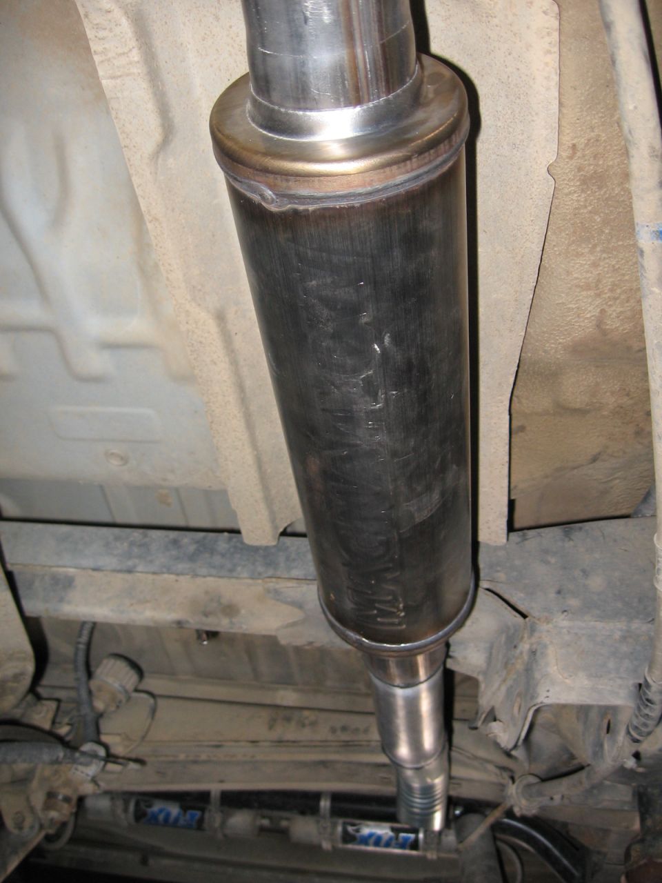 Underside view of a vehicle's exhaust muffler and pipe