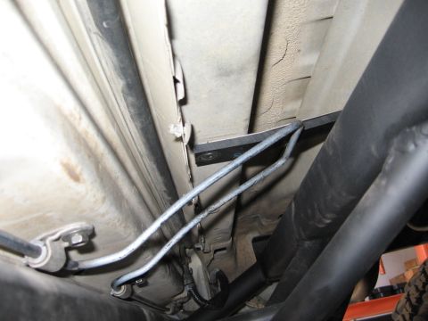 1993 Toyota 4Runner - Close-up view of the underbody of a vehicle, revealing fuel lines and a black metal bar with peeling paint.