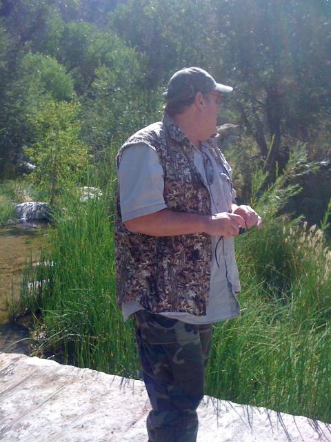 1990 Ford Bronco - Photo of a man in a camouflage vest standing beside a creek, not a technical document.