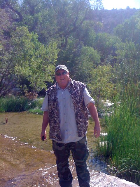 1990 Ford Bronco - Photo of a man in a camo vest standing in a shallow creek, not a technical document.
