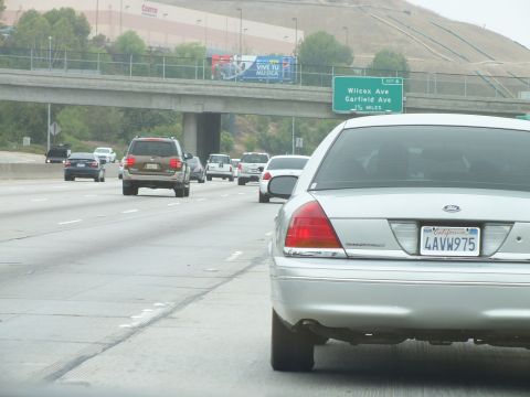 2003 Ford Crown Victoria - Photo of a silver Ford Crown Victoria on a freeway near a Wilcox/Garfield Ave exit sign, not a technical document.