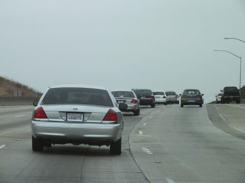 2003 Ford Crown Victoria - Photo of a silver Crown Victoria leading traffic on a hazy multi-lane freeway, not a technical document.