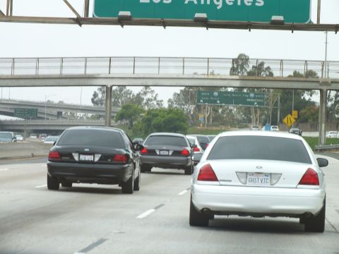 2003 Ford Crown Victoria - Photo of a white Crown Victoria in freeway traffic beneath Los Angeles overhead signs, not a technical document.