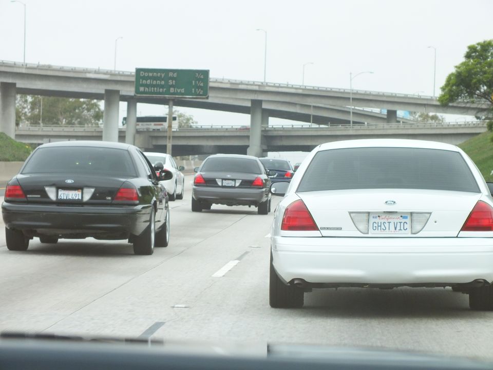 White Crown Victoria GHST VIC near freeway interchange and exit signs