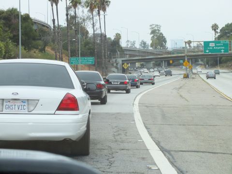 2003 Ford Crown Victoria - Photo of a white Crown Victoria in freeway traffic with palms and a 101 North sign, not a technical document.