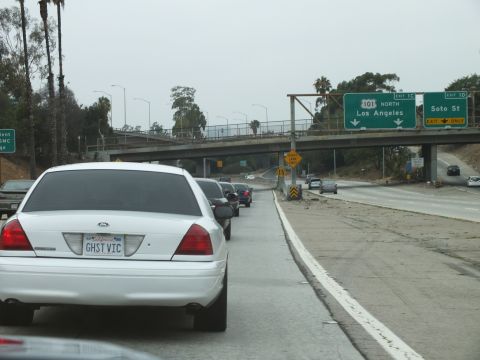 2003 Ford Crown Victoria - Photo of a white Crown Victoria on a freeway beneath 101 North and Soto St signs, not a technical document.
