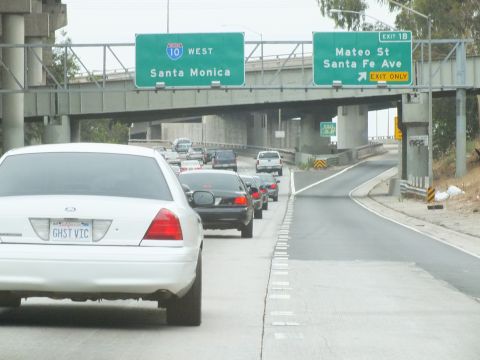 2003 Ford Crown Victoria - Photo of a white Crown Victoria leading traffic under freeway exit signs, not a technical document.