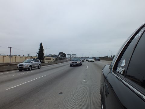2003 Ford Crown Victoria - Photo from inside a car showing freeway traffic under an overcast sky, not a technical document.
