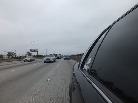2003 Ford Crown Victoria - Photo from a car window of freeway traffic with a distant billboard, not a technical document.