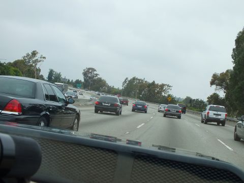 2003 Ford Crown Victoria - Photograph of multilane freeway traffic taken through a windshield over a textured dashboard.