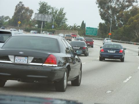 2003 Ford Crown Victoria - Photograph of a black Crown Victoria and traffic on a freeway near a green Robertson Blvd exit sign.