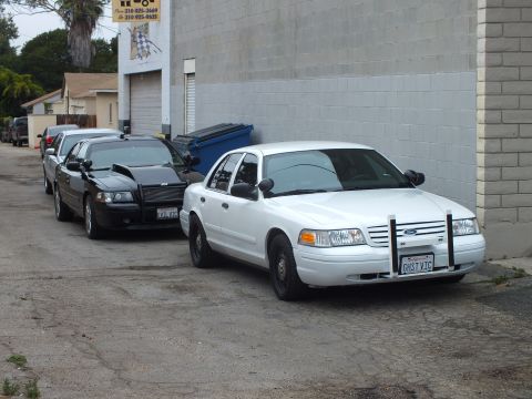 2003 Ford Crown Victoria - Photo of a white Ford Crown Victoria with grille guard parked alongside a black sedan.