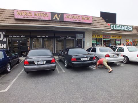 2003 Ford Crown Victoria - Photo of Ford Crown Victoria sedans parked in front of a sushi restaurant and cleaners.