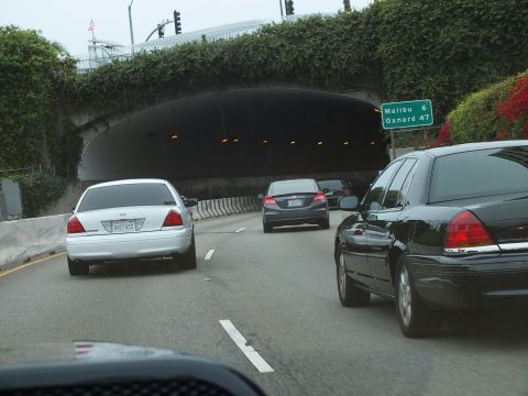 2003 Ford Crown Victoria - Photo of white and black Crown Victorias approaching a freeway tunnel beneath a Malibu/Oxnard sign.