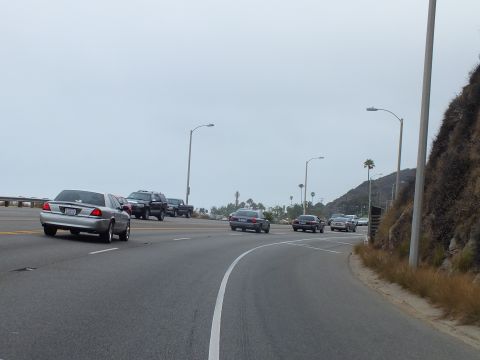 2003 Ford Crown Victoria - Photo of cars driving on a coastal highway, not a technical document.