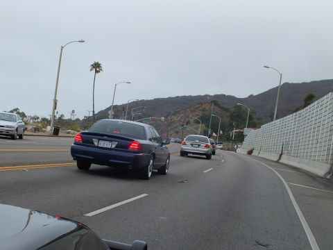 2003 Ford Crown Victoria - Photo of cars on a coastal highway, not a technical document.
