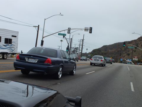 2003 Ford Crown Victoria - Photo of cars at a coastal highway intersection, not a technical document.