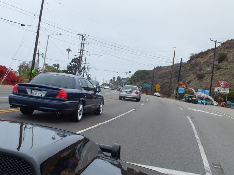 2003 Ford Crown Victoria - Photo of cars on a coastal highway, not a technical document.