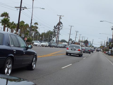 2003 Ford Crown Victoria - Photo of cars on a coastal boulevard, not a technical document.
