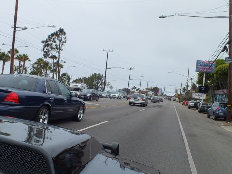 2003 Ford Crown Victoria - Photo of traffic on a coastal highway, not a technical document.
