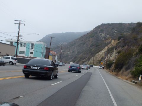 2003 Ford Crown Victoria - Photo of cars on a coastal highway, not a technical document.