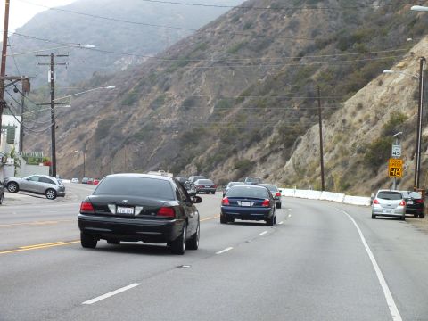 2003 Ford Crown Victoria - Photo of traffic on a coastal highway, not a technical document.