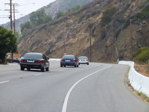 2003 Ford Crown Victoria - Photo of cars on a coastal highway, not a technical document.