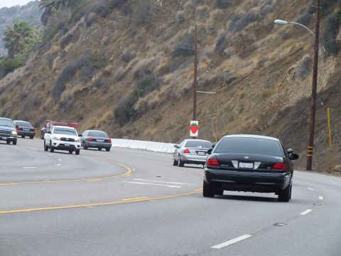 2003 Ford Crown Victoria - Photo of cars on a coastal highway, not a technical document.