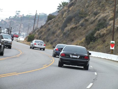 2003 Ford Crown Victoria - Photo of cars on a coastal highway, not a technical document.