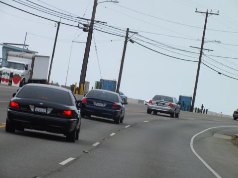 2003 Ford Crown Victoria - Photo of traffic on a coastal highway, not a technical document.