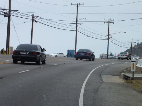 2003 Ford Crown Victoria - Photo of cars on a coastal highway, not a technical document.