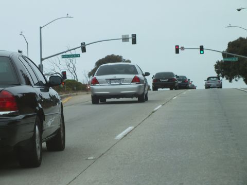2003 Ford Crown Victoria - Road photo of cars approaching overhead traffic signals on a multi-lane road, not a technical document.