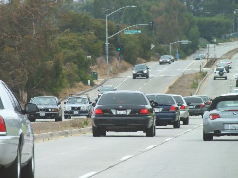 2003 Ford Crown Victoria - Driving photo of traffic on a divided highway near a John Tyler street sign, not a technical document.