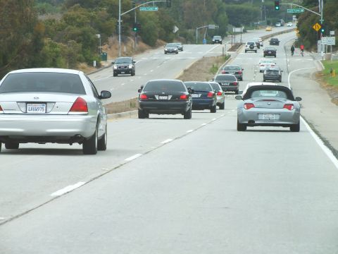 2003 Ford Crown Victoria - Road photo of vehicles on a divided highway with distant green street signs, not a technical document.