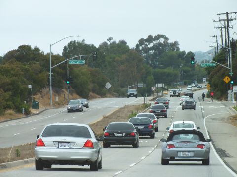 2003 Ford Crown Victoria - Driving photo of traffic on a sloping divided highway near green signs and signals, not a technical document.