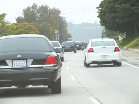2003 Ford Crown Victoria - Driving photo of a black Ford beside a white sedan on a multi-lane road, not a technical document.