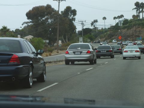 2003 Ford Crown Victoria - Photograph taken from inside a vehicle of traffic on a coastal highway, not a technical document.