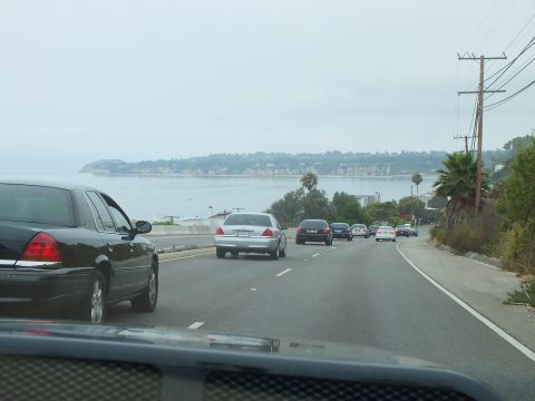 2003 Ford Crown Victoria - Photograph taken from a car of traffic on a coastal highway with an ocean view, not a technical document.