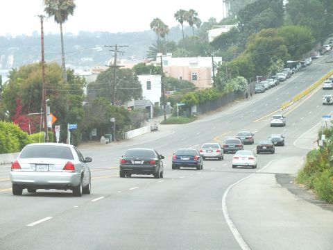 2003 Ford Crown Victoria - Photograph of a silver Crown Victoria and traffic descending a coastal highway, not a technical document.