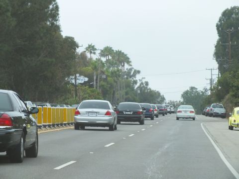 2003 Ford Crown Victoria - Photograph of a silver Crown Victoria and black sedan in coastal highway traffic, not a technical document.