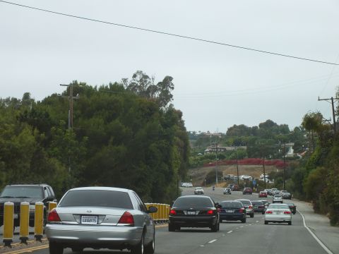 2003 Ford Crown Victoria - Photograph of a silver Crown Victoria and other sedans on a coastal highway, not a technical document.
