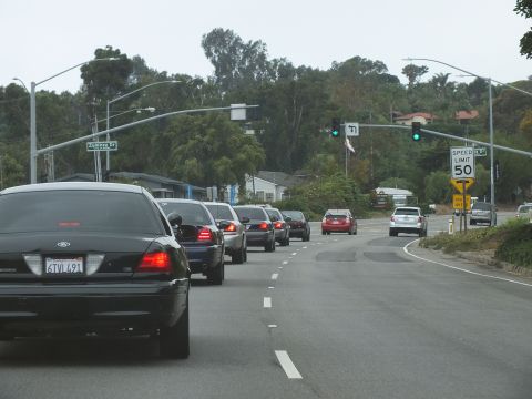 2003 Ford Crown Victoria - Photograph of cars stopped at a signalized intersection on a 50 mph road, not a technical document.