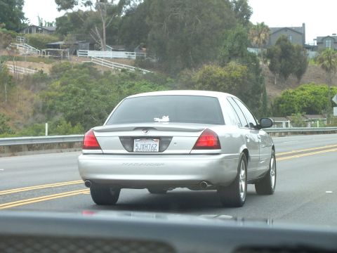 2003 Ford Crown Victoria - Photograph of a silver Mercury Marauder on a coastal highway, not a technical document.