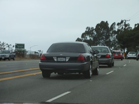 2003 Ford Crown Victoria - Photograph of Crown Victoria sedans on a highway with power poles, not a technical document.