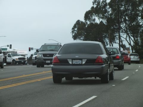 2003 Ford Crown Victoria - Photograph of a Crown Victoria and other vehicles near an intersection, not a technical document.