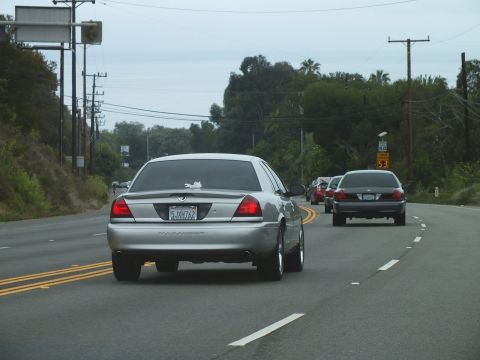 2003 Ford Crown Victoria - Photograph of a Marauder and sedans on a coastal highway, not a technical document.