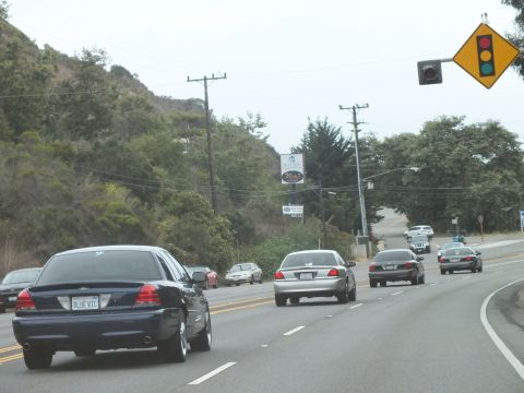 2003 Ford Crown Victoria - Photograph of a blue Crown Victoria and sedans approaching a signal, not a technical document.