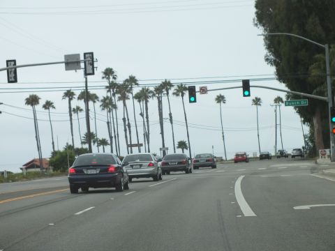 2003 Ford Crown Victoria - Photograph of sedans at a green light by a Busch Dr sign, not a technical document.