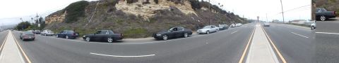 2003 Ford Crown Victoria - Wide panoramic photograph of cars parked along a coastal highway, not a technical document.